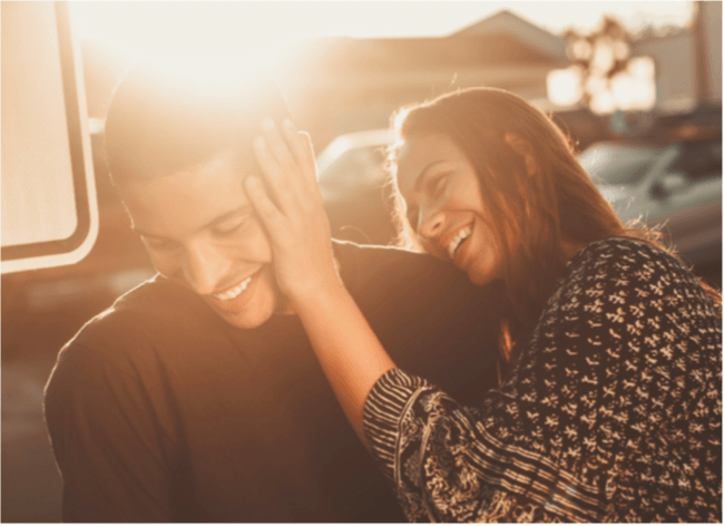 Photo of a woman touching the man's face with a brown filter effect and a bright sunlight on the upper left